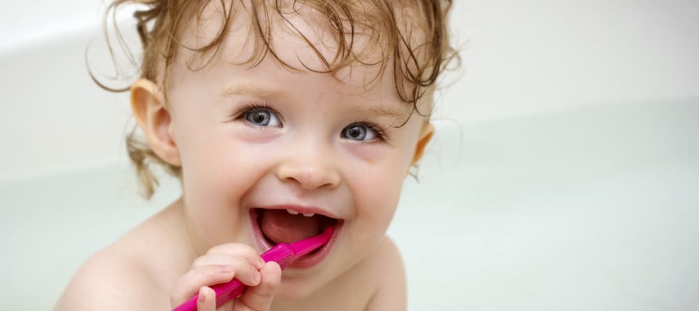 A toddler brushing her teeth