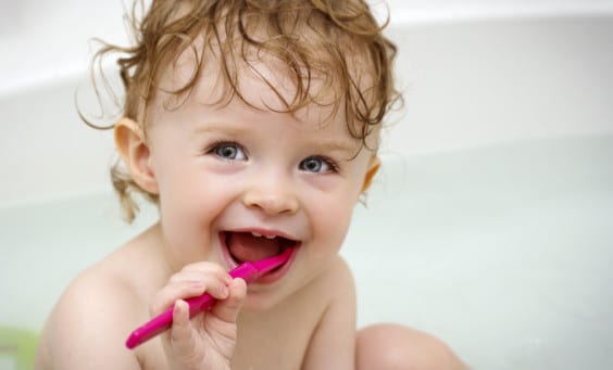 A toddler brushing her teeth