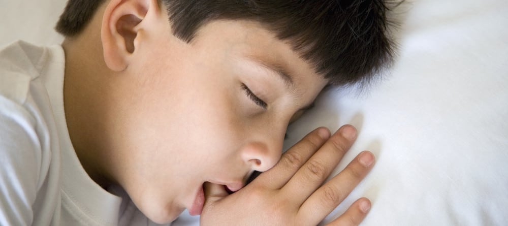 A boy sucks his thumb in his sleep