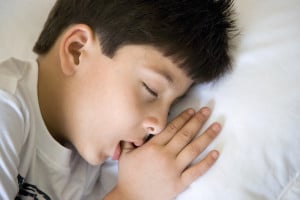 A boy sucks his thumb in his sleep