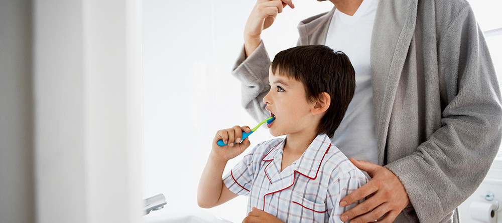 A man and his son brush their teeth together