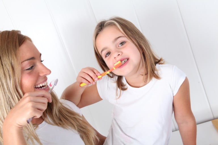 Mother and Daughter Brushing Their Teeth