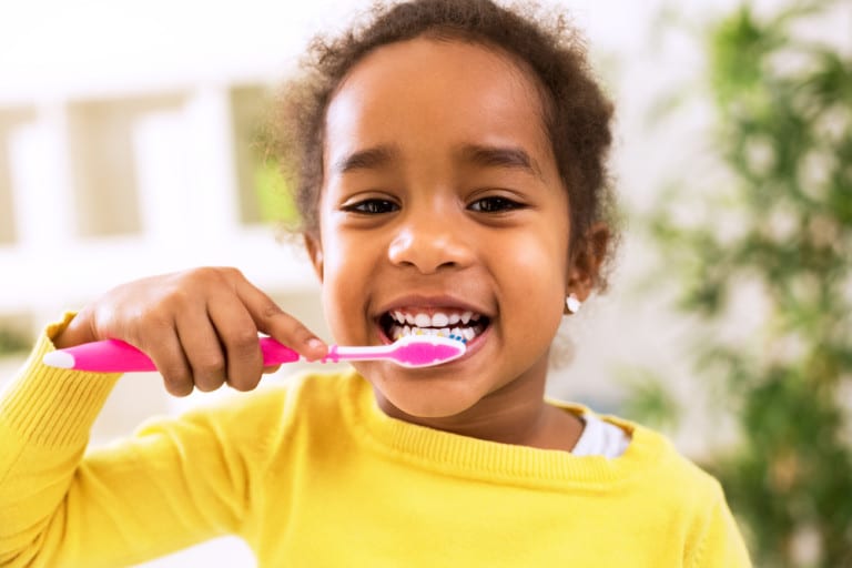 a kid brushing her teeth